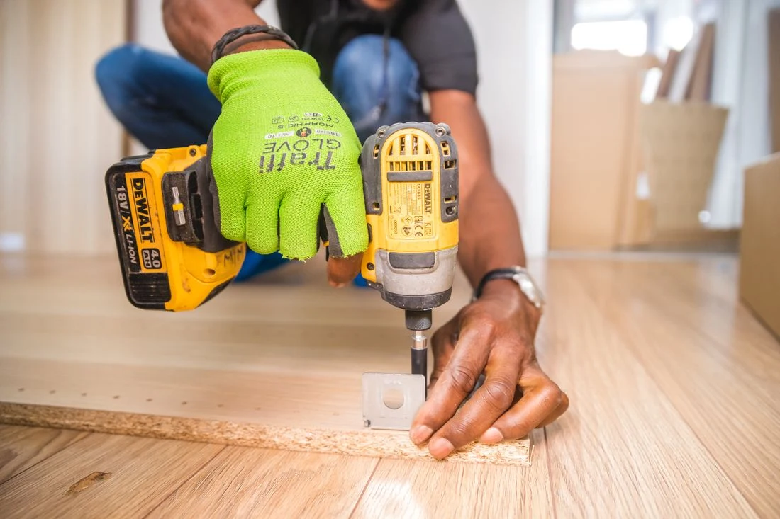Worker using a cordless drill on a build