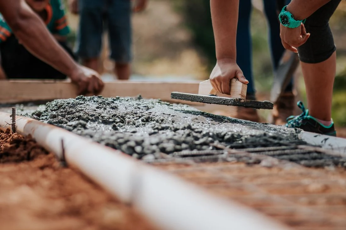 Worker laying screed on a construction floor