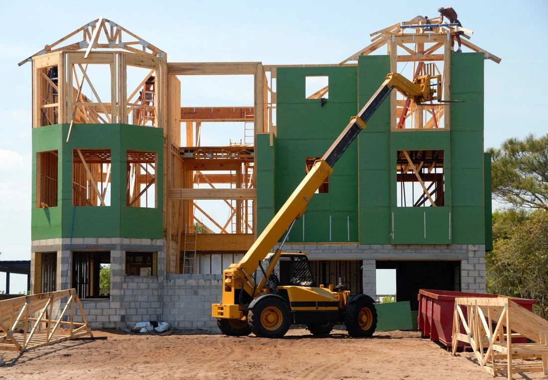 Timber-frame building under construction with a crane