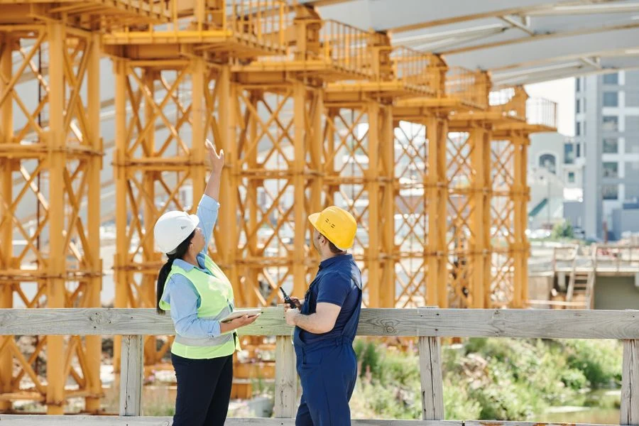 Two workers inside a timber-frame structure